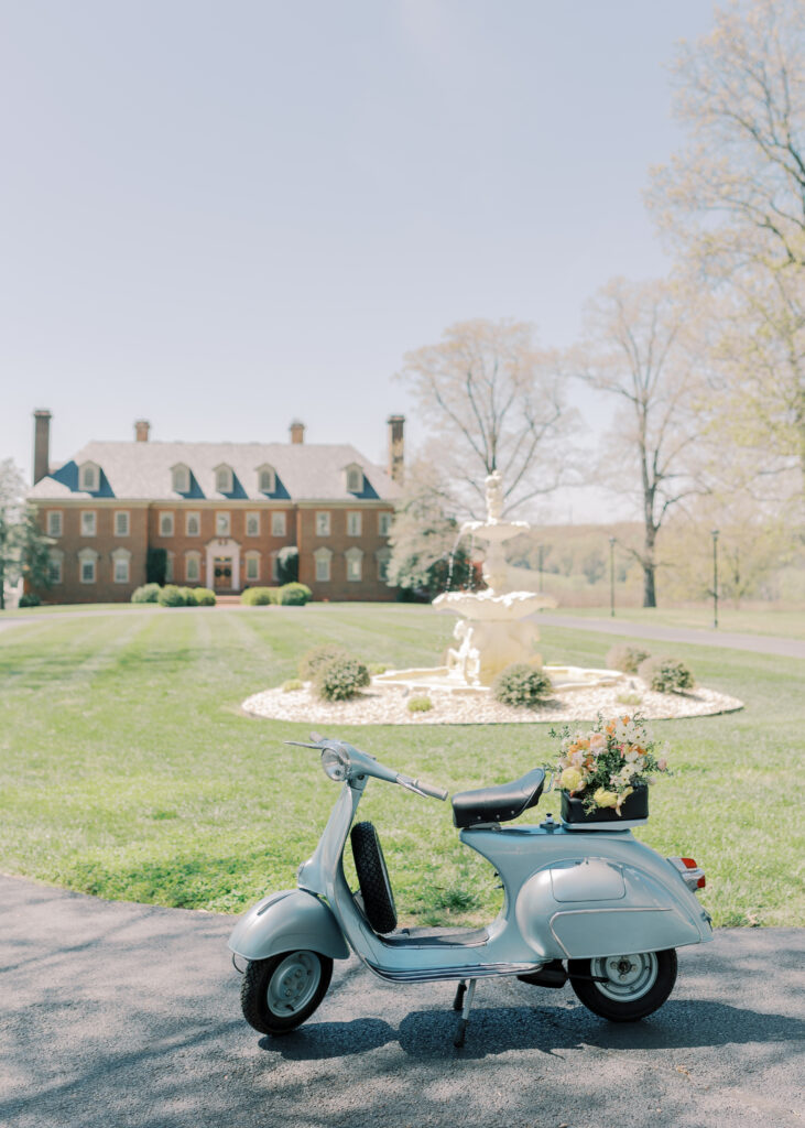 Vintage whimsy with a 1962 blue vespa with flowers in front of Estate at River Run.