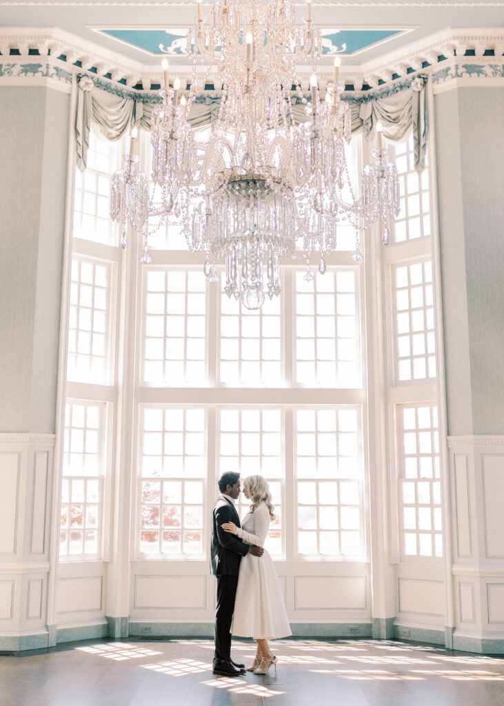 Couple embracing in the blue, Wedgewood, ballroom at The Estate at River Run.