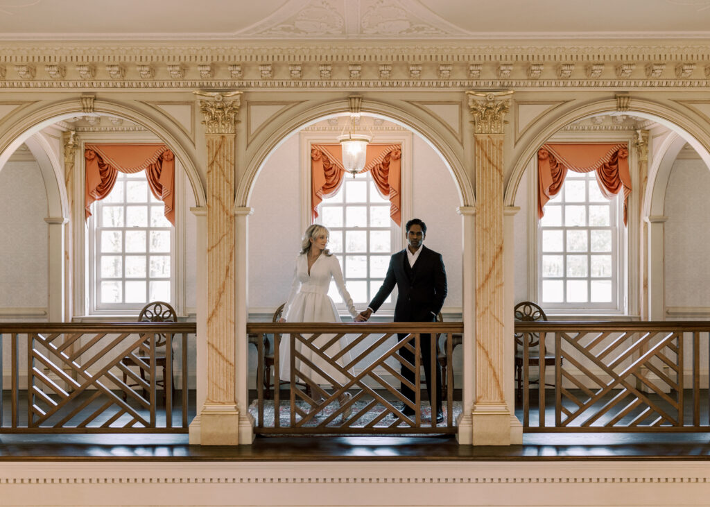 Couple holding hands framed by columns. 